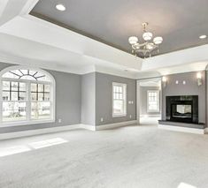 an empty living room with two windows and a fireplace