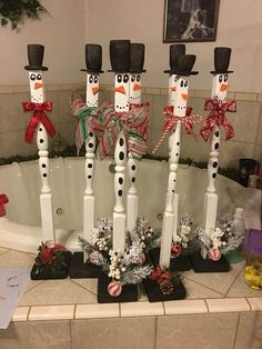 the snowmen are standing in front of the bathtub decorated for christmas