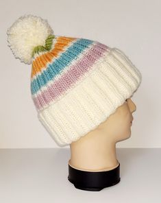 a white hat with multicolored stripes and a pom - pom on top