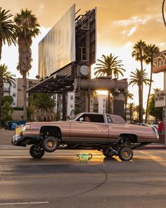 a pink car parked in front of a tall building