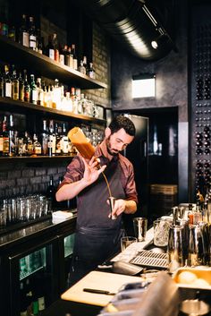 a man in an apron preparing food at a bar