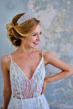 a woman in a white dress with a tiara on her head and back to the camera