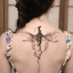 the back of a woman's neck with a bird tattoo on it