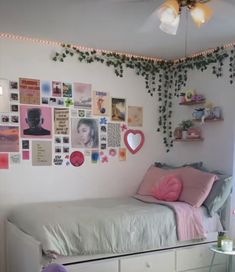 a bedroom with a bed, dresser and lots of pictures on the wall above it