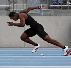 a man is running on a track with his leg in the air and one hand out