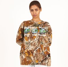 Looking for a stylish and eco-conscious addition to your wardrobe? Check out our Women’s Save the Earth Camo Long Sleeve Tee! Made from 100% heavyweight cotton, this tee features an allover camouflage print and a graphic on the front that reads "save the earth love the world" with earths. We've used a custom wash process to give the tee a soft hand feel, making it comfortable to wear all day long. With its unique design and eco-friendly message, this tee is the perfect choice for anyone who want Fall Camouflage T-shirt With Crew Neck, Fall Camouflage Crew Neck T-shirt, Camouflage Graphic Print Relaxed Fit Tops, Camouflage T-shirt For Fall, Camouflage Tops For Outdoor Fall Activities, Camouflage All Over Print Cotton Tops, Camouflage All-over Print Cotton Tops, Camouflage Cotton Sweatshirt For Streetwear, Camouflage Graphic Print Tops For Outdoor