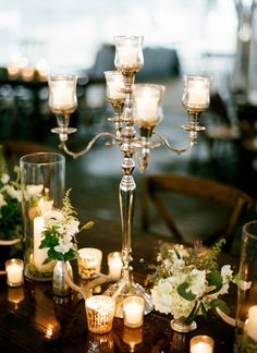 a table topped with lots of candles and flowers