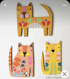 three wooden cutouts of cats sitting next to each other