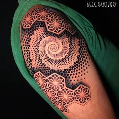 a man's arm with an intricate tattoo design on the upper half of his arm