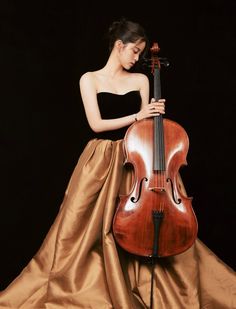 a woman in a brown dress holding a violin