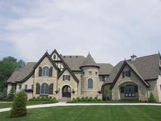 a large house with lots of windows on the front and side of it, surrounded by lush green grass