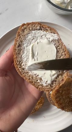 a person is spreading cream on a piece of bread