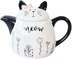 a ceramic teapot with a cat design on the front and side, says meow