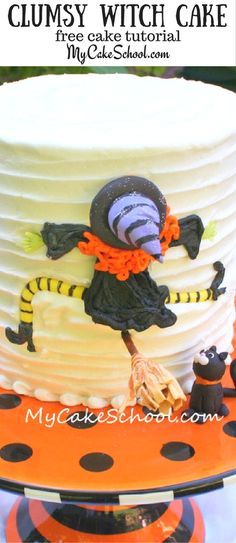 a white cake with black and orange decorations on it's sides, sitting on top of a table