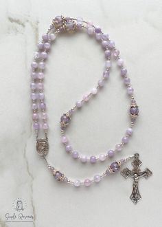 Handmade, heirloom-quality rosary 6 mm Cape Amethyst Ave beads, 8 mm Floral Lampwork Pater beads, and 3 mm Cape Amethyst accents All components are solid sterling silver Solid sterling silver centerpiece and crucifix Measures approximately 18.5" long The rosary is made using Soft Flex wire! It is a durable and delicate wire made of woven stainless steel. Soft Flex rosaries have a one year guarantee of durability. These beads would make the best gift for a Confirmation, First Communion, Baptism, Rosary Hand Made, Rosary Necklace Diy, Beaded Rosary Diy, Diy Rosary Beads, Pretty Rosary, Rosary Aesthetic, Diy Rosary Necklace, Amethyst Rosary, Diy Rosary