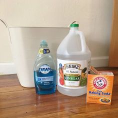 the contents of a dishwasher sitting on top of a wooden floor next to a white bucket