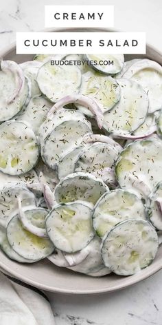 cucumber salad in a white bowl on a marble table with text overlay