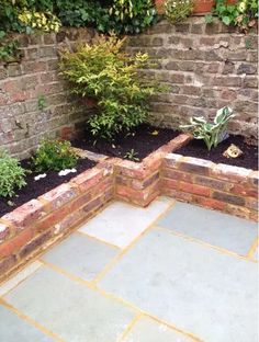 an outdoor garden with brick walls and plants