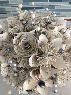 an origami flower bouquet made out of book pages with pearls and pearls on it