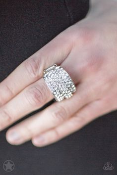 a woman's hand with a diamond ring on top of her left hand, wearing a black shirt