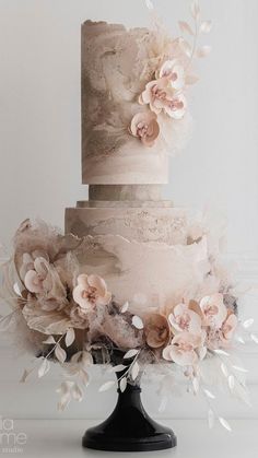 a three tiered cake with flowers on top