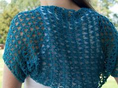 a woman wearing a blue crochet shawl