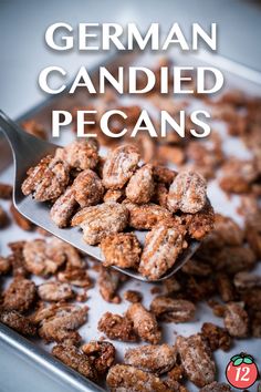 a spoon full of german candied pecans sitting on top of a pan filled with them