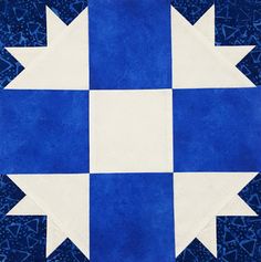 a blue and white patchwork quilt with an arrow design on the center, which has been stitched together