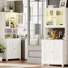 a kitchen with white cupboards and cabinets next to a potted plant on the floor