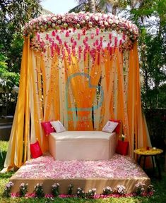 an outdoor wedding setup with flowers on the bed and draping over the top