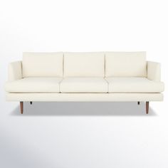 a white couch sitting on top of a wooden floor