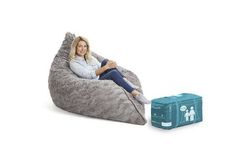 a woman sitting on a bean bag chair next to a blue box