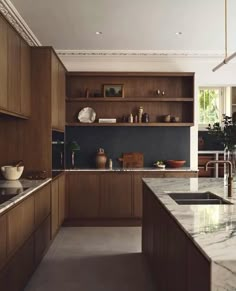 a large kitchen with wooden cabinets and marble counter tops, along with an island in the middle