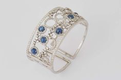 For Sale on 1stdibs -  A unique beautiful design. 9.11 carats of cabochon blue sapphires, 5.90 carats of white round brilliant cut diamonds. 18k white gold Approximately 1.35 Luxury Blue Cuff Bracelet, Blue Round Cuff Bracelet For Formal Occasions, Elegant Blue Cuff Bracelet With Polished Finish, Diamond Cuff Bracelet, Round Brilliant, Round Brilliant Cut Diamond, Brilliant Cut Diamond, Cuff Bracelet, Fashion Statement