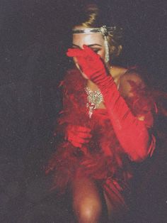 a woman in a red dress and feathered gloves