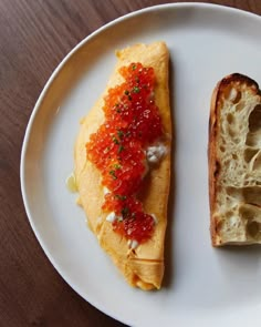 a piece of bread with red sauce on it next to a slice of bread that has been cut in half