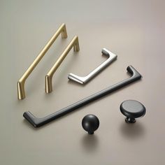 an assortment of handles and knobs on a gray surface with gold accents, including one for the door