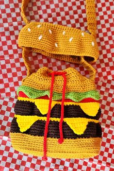 a crocheted hamburger bag sitting on top of a red and white checkered table cloth