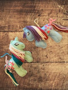 two small stuffed animals are on a wooden table with string wrapped around them and tied to strings