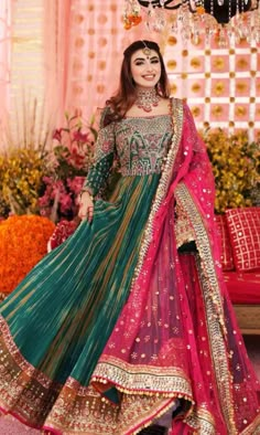 a woman in a green and pink lehenga