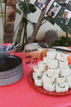 a table topped with lots of food next to a red table cloth covered tablecloth