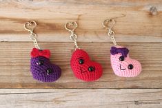 three crocheted keychains with hearts and bears on them hanging from chains