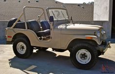 an old jeep is parked in front of a building