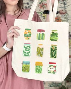 a woman holding up a bag with jars on it