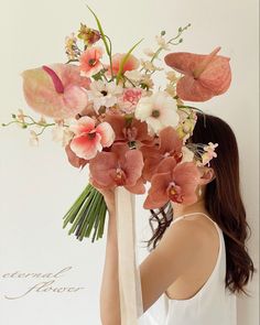 a woman holding a bouquet of flowers in front of her face