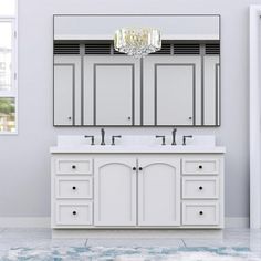 a bathroom vanity with two sinks and a large mirror above it, along with a chandelier