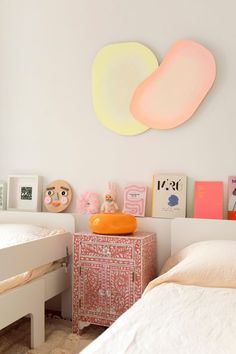 a bedroom with two twin beds and an art piece on the wall above them,