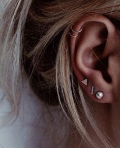 a woman's ear with two piercings on it