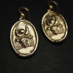 Hand sculpted Egyptian ancient goddess Hathor earrings. Light and classically simple.Hathor in ancient Egypt was a sky goddess, goddess of fertility, birthing, nursing infants, maternal care, the patron of love, dance and joy, represented variously as a cow, with a cow's head or ears, or with a solar disc between a cow's horns. Her name means 'House of Horus'.- Hand sculpted charm- Solid yellow bronze also called jeweler gold bronze charm.- 14K gold filled ear wire. - Gold filled has 100 times m Egyptian Jewelry Ancient, Egyptian Earrings, Ancient Egyptian Jewelry, Ancient Goddesses, Cow Horns, Cow Head, Egyptian Jewelry, Ancient Egypt, Egypt