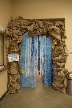 an open door with some paper on the outside and blue curtains hanging from it's sides